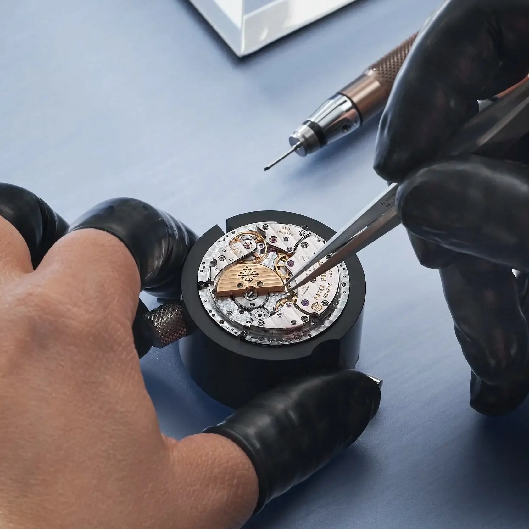TimeRepair watchmaker servicing a mechanical watch movement with precision tools